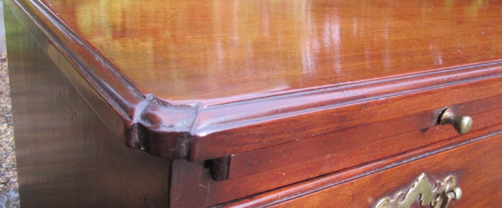 An 18th-century Georgian mahogany chest of drawers featuring four graduated drawers with brass handles, a brushing slide, and bracket feet. View IV