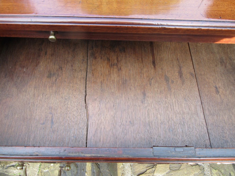 An 18th-century Georgian mahogany chest of drawers featuring four graduated drawers with brass handles, a brushing slide, and bracket feet. View VII
