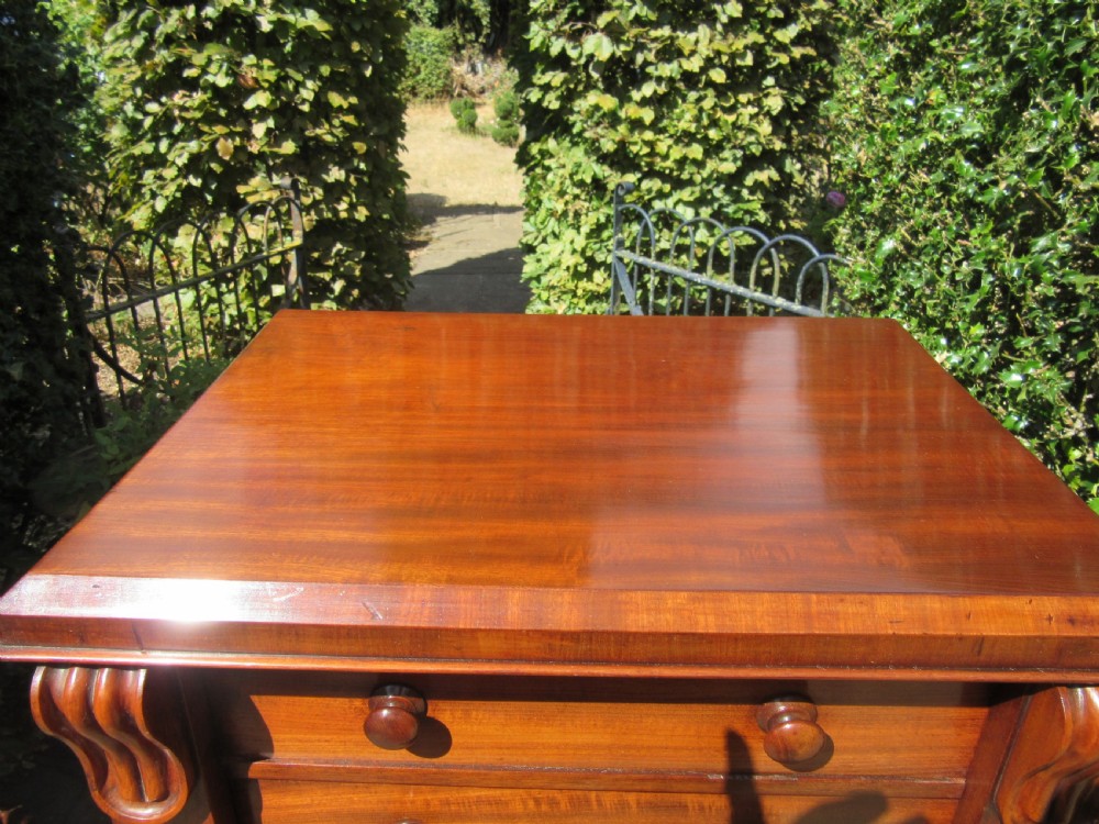 A tall Victorian mahogany Wellington chest featuring stacked drawers with turned handles, decorative upper corbels, and a right-hand hinged locking bar. View VI