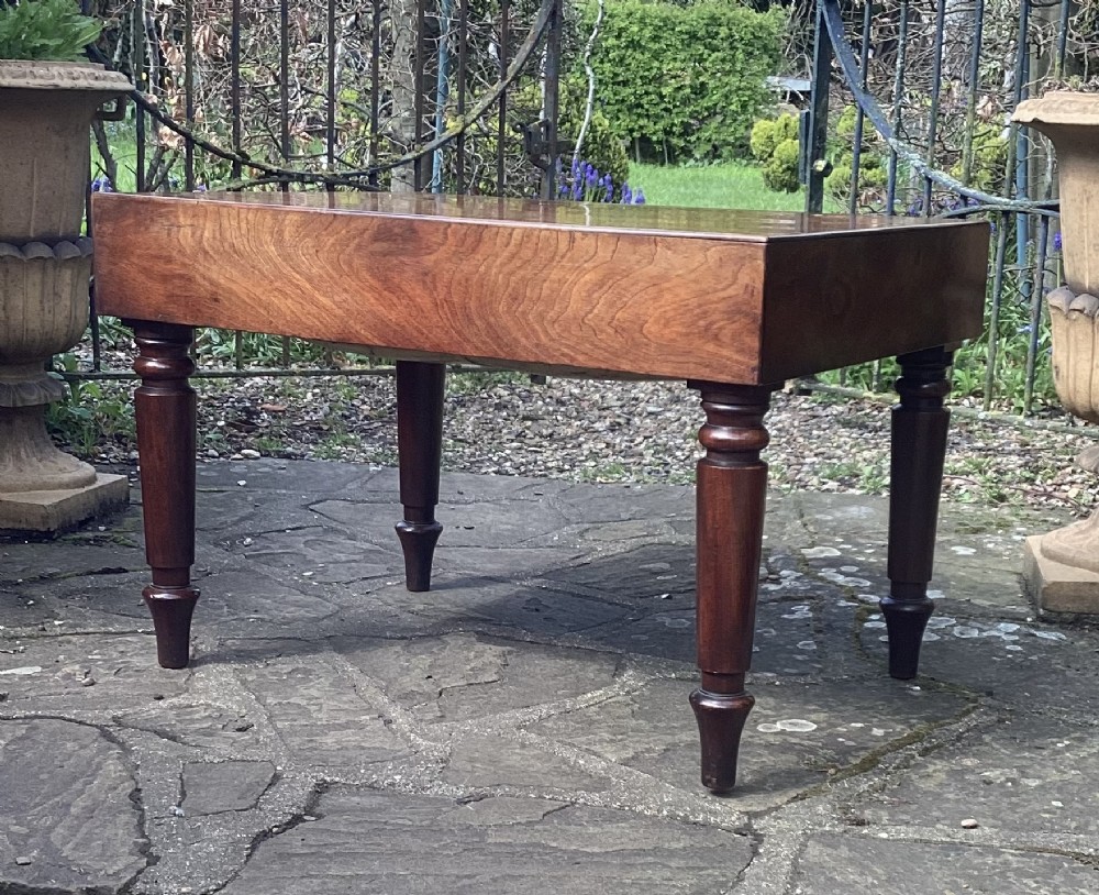 A large rectangular mahogany coffee table dating from circa 1840 with turned legs and a deep flame mahogany apron.
