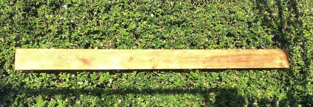 A long horizontal painted pine sign with metal stud lettering spelling out MAN SHALL NOT LIVE BY BREAD ALONE. View VI