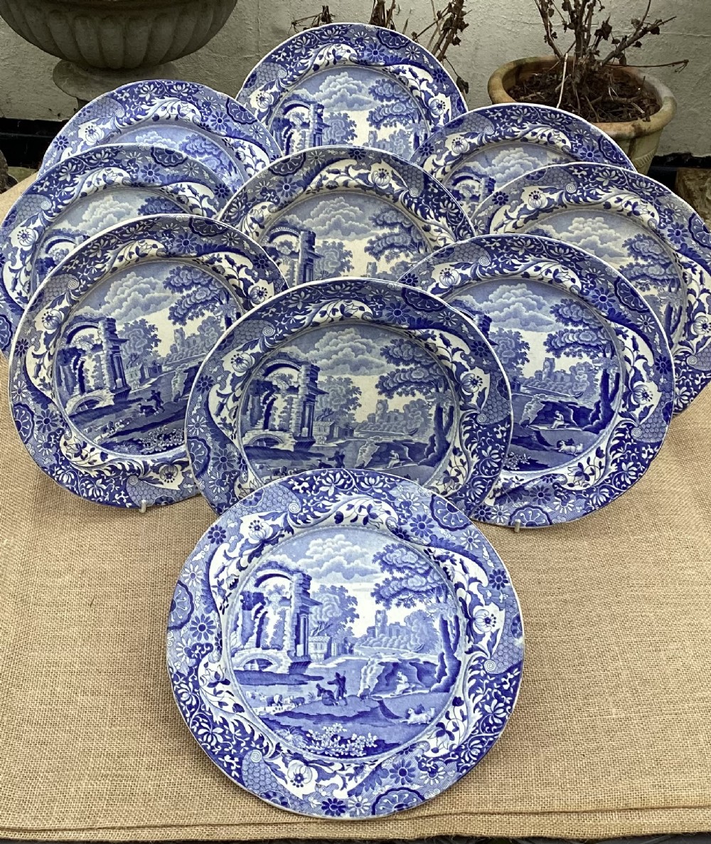 A set of ten Georgian Spode earthenware plates featuring the blue and white Italian pattern with classical ruins and an Imari floral border.