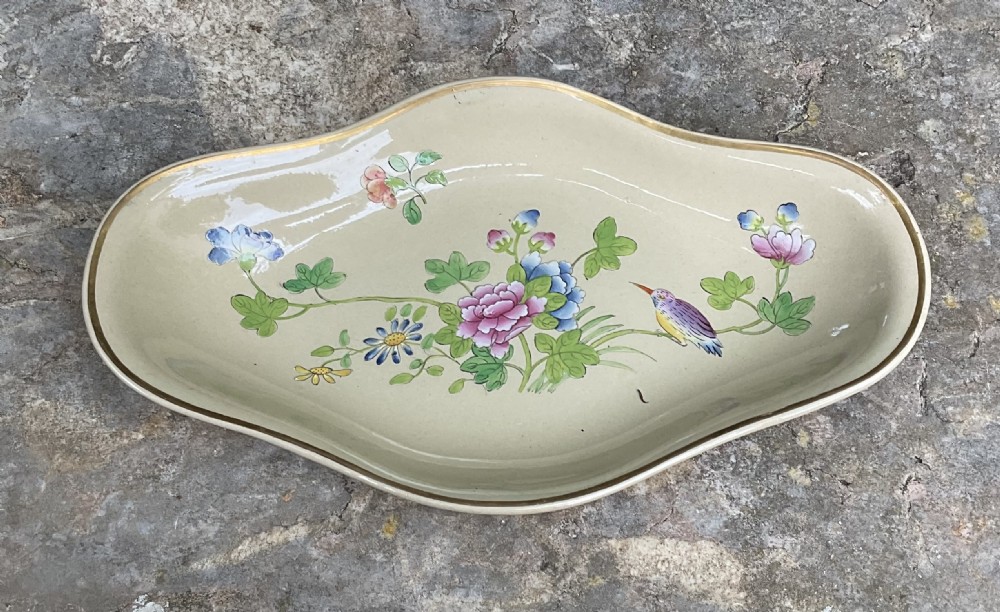 An antique Wedgwood drabware dessert service featuring several round plates and an elongated serving dish decorated with hand-painted botanical flowers and birds. View III