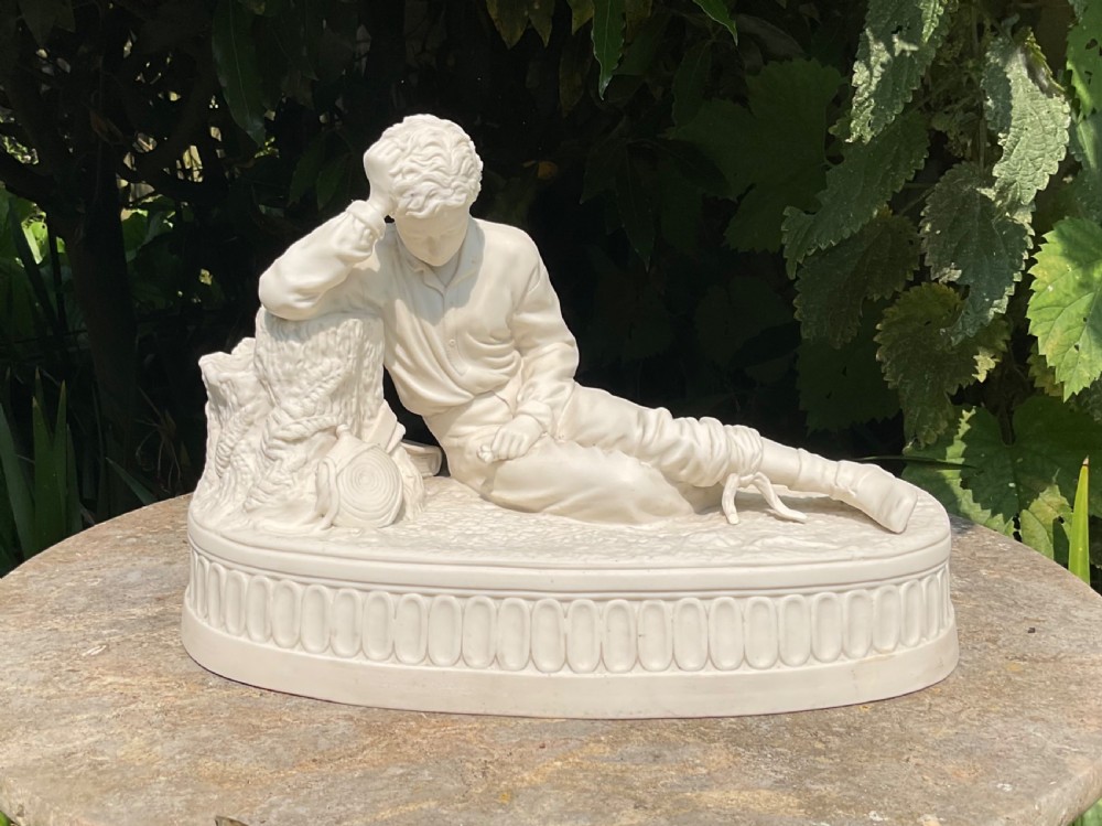 An off-white Victorian Parian porcelain statuette of a reclining soldier leaning against a tree stump on an oval relief-moulded base.