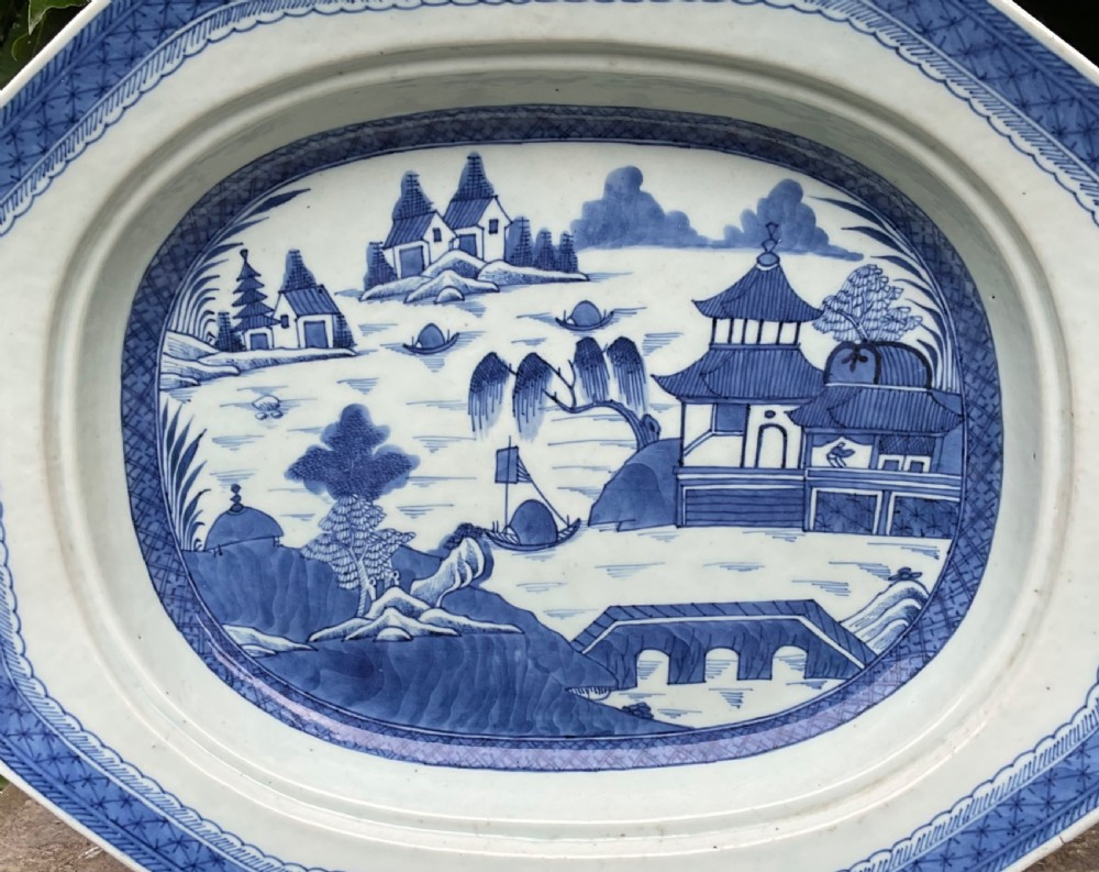 A 19th-century octagonal Chinese porcelain serving platter decorated with a hand-painted blue and white river landscape scene. View II