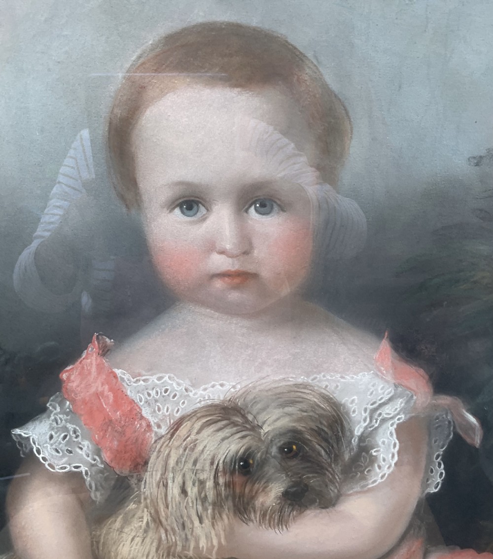A large Victorian pastel portrait depicting a young child in a pink dress holding a small dog, set inside a gilded wooden frame. View II