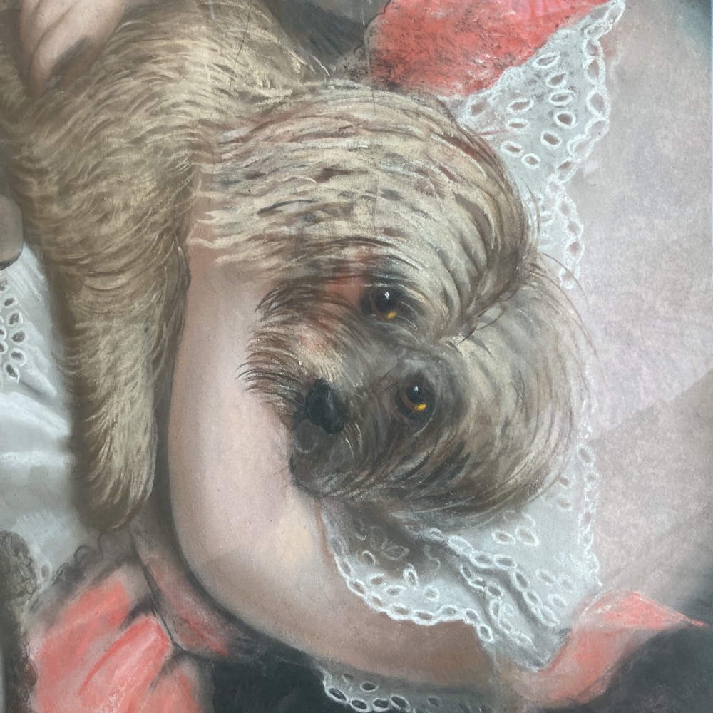A large Victorian pastel portrait depicting a young child in a pink dress holding a small dog, set inside a gilded wooden frame. View VII
