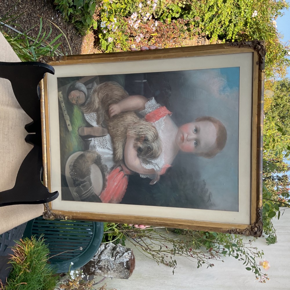 A large Victorian pastel portrait depicting a young child in a pink dress holding a small dog, set inside a gilded wooden frame. View VIII