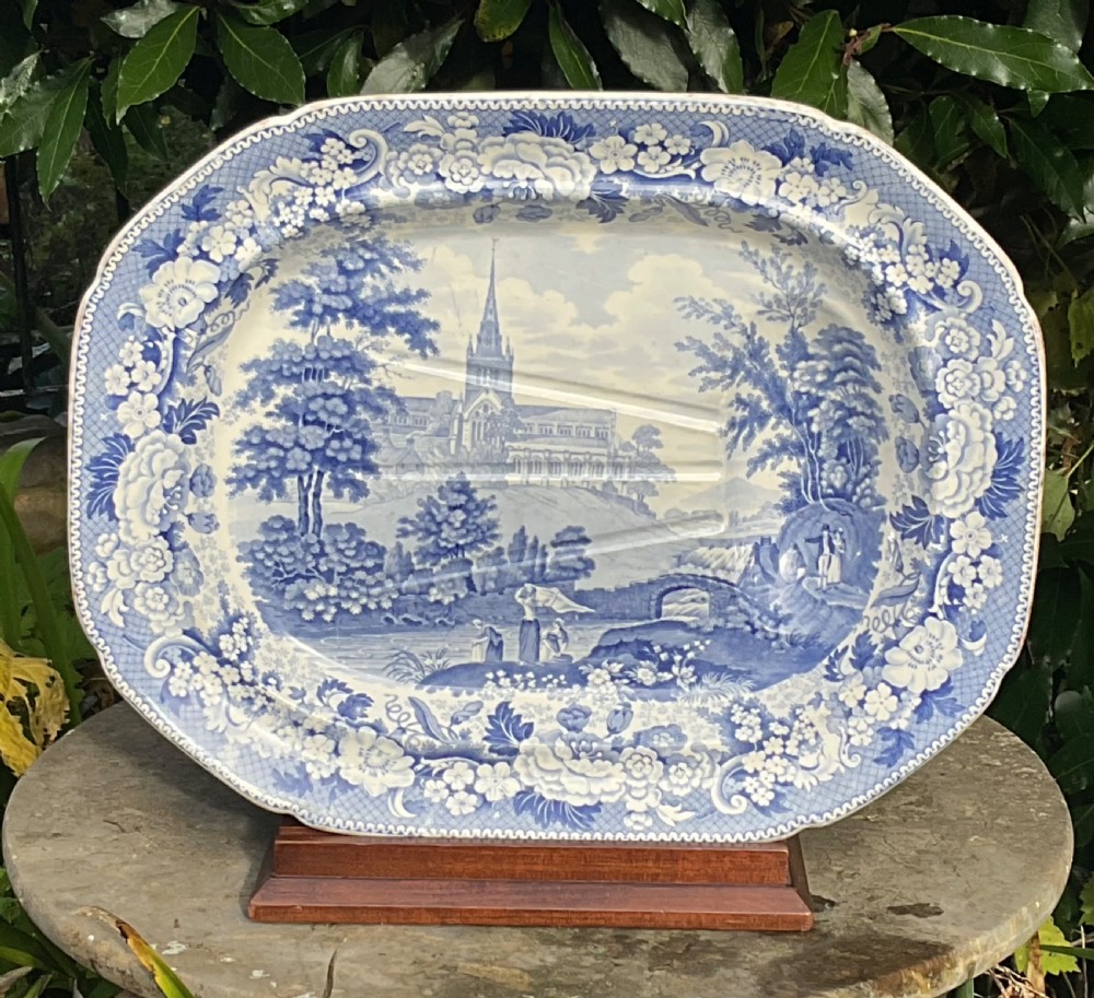 A large oval Victorian blue and white transferware meat platter featuring a central landscape of Glasgow Cathedral with molded drainage channels and a floral border.