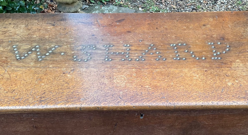 A rectangular Georgian dark oak blanket box featuring brass studding on the lid, wrought iron side handles, and a moulded plinth base. View III