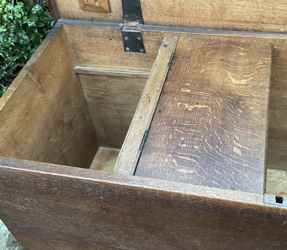 A rectangular Georgian dark oak blanket box featuring brass studding on the lid, wrought iron side handles, and a moulded plinth base. View VI