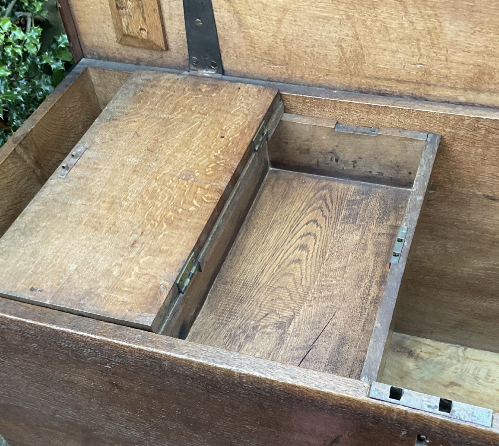 A rectangular Georgian dark oak blanket box featuring brass studding on the lid, wrought iron side handles, and a moulded plinth base. View VIII