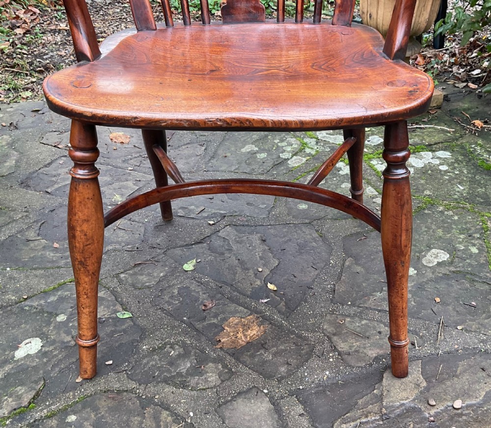 A Georgian yew and elm wheel back Windsor armchair with a hooped back, shaped saddle seat, swept arms, and turned legs joined by a curved stretcher. View VI