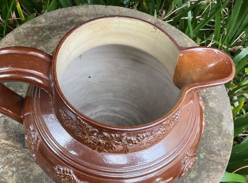 A large Victorian brown glazed stoneware jug featuring a relief-moulded profile portrait of Queen Victoria within an ornate cartouche. View VIII