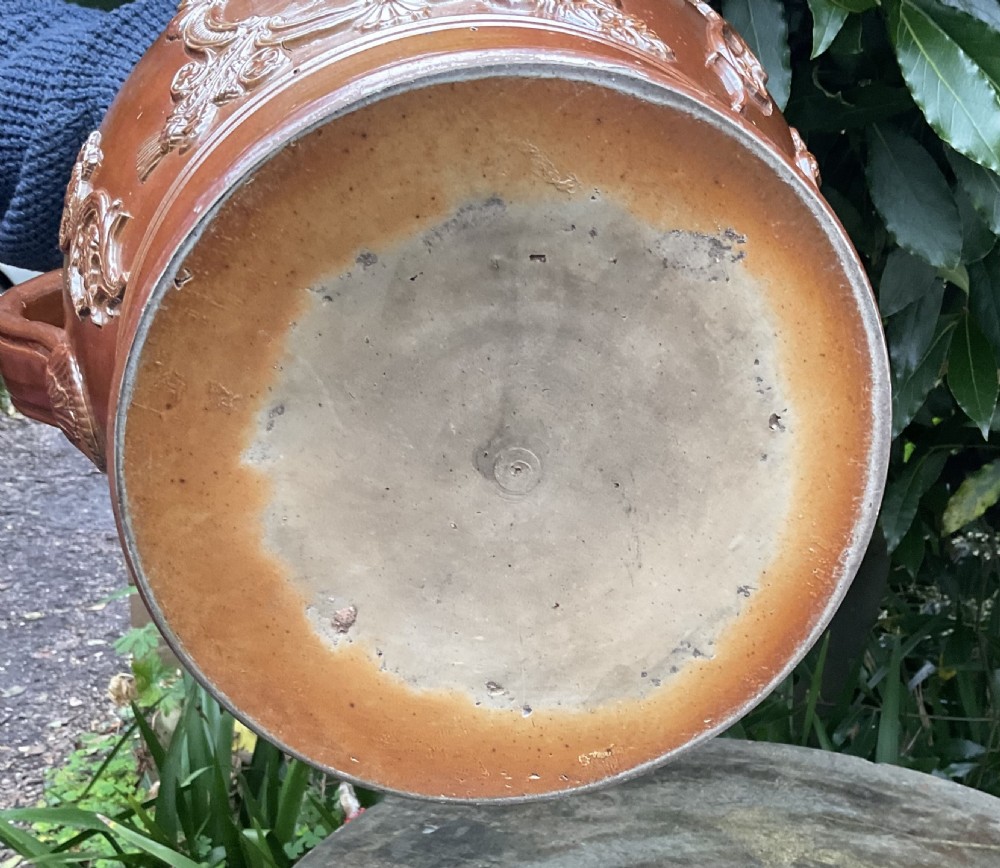 A large Victorian brown glazed stoneware jug featuring a relief-moulded profile portrait of Queen Victoria within an ornate cartouche. View X