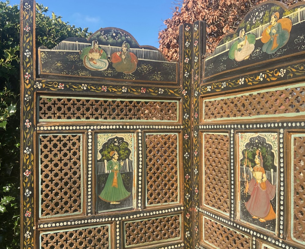A four-panel wooden folding screen featuring intricate carved fretwork lattice panels and hand-painted figures set within decorative borders. View II