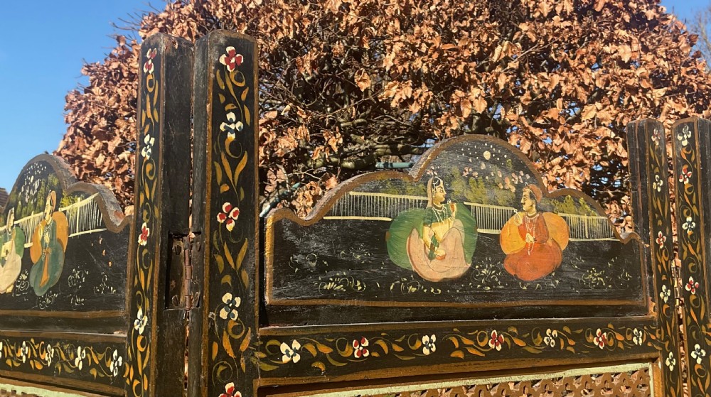 A four-panel wooden folding screen featuring intricate carved fretwork lattice panels and hand-painted figures set within decorative borders. View V