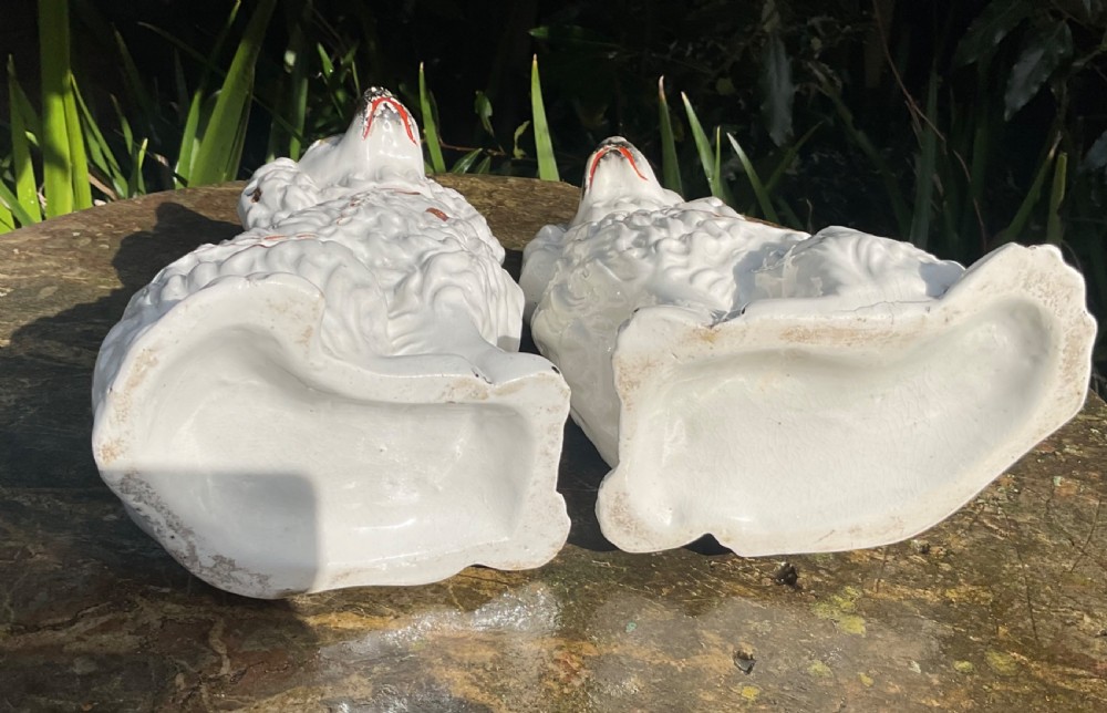 A pair of Victorian white glazed earthenware Staffordshire spaniel dog figurines with gilded accents and hand-painted facial features. View V
