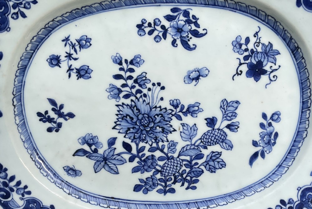 An oval Georgian-era Chinese export porcelain platter featuring hand-painted cobalt blue floral motifs on a white ground with decorative rim borders. View II