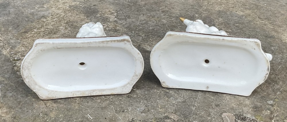 A pair of Victorian Staffordshire white glazed ceramic figures depicting a recumbent royal lion and unicorn with gilded detailing on moulded bases. View V