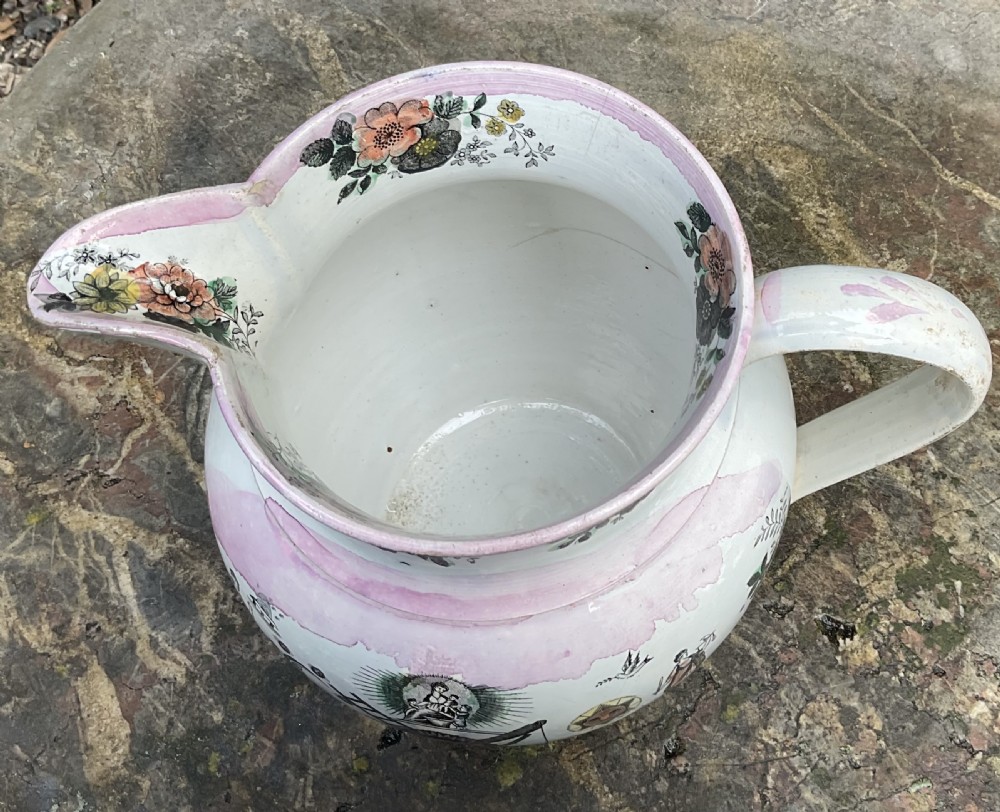 A large 19th-century white earthenware jug featuring pink splash lustre glaze, floral rim motifs, and a detailed Farmers Arms transfer print. View VI