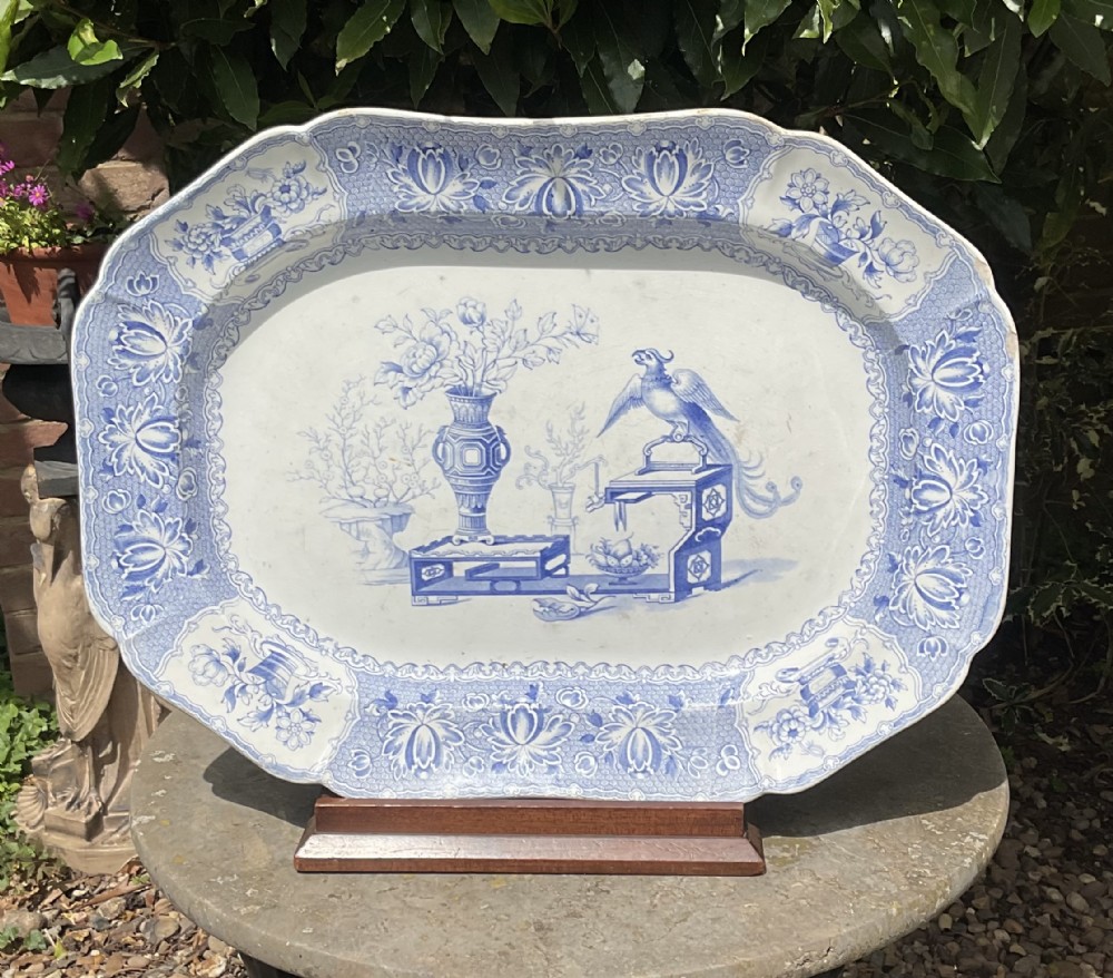 An octagonal antique blue and white transfer-printed ceramic serving platter featuring a central bird motif and ornate floral borders.