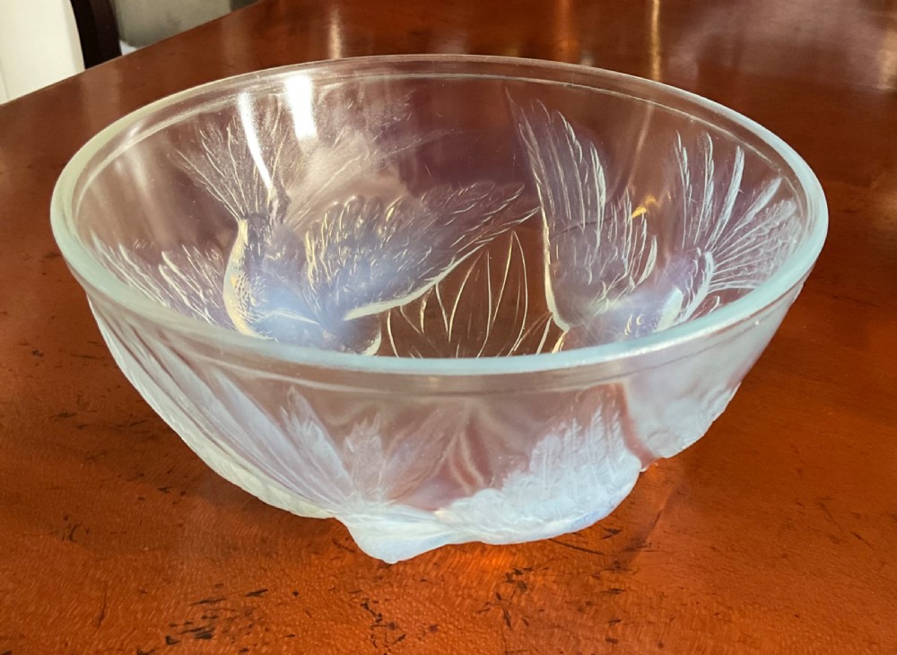 An Art Deco translucent opalescent glass bowl decorated with embossed motifs of birds in flight.