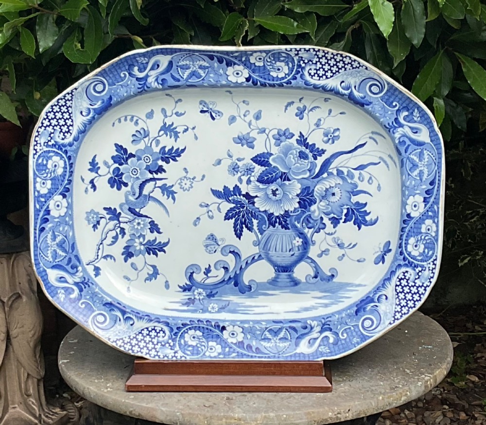 An oval blue and white transferware earthenware serving platter decorated with a central urn floral pattern and a detailed outer scroll border.