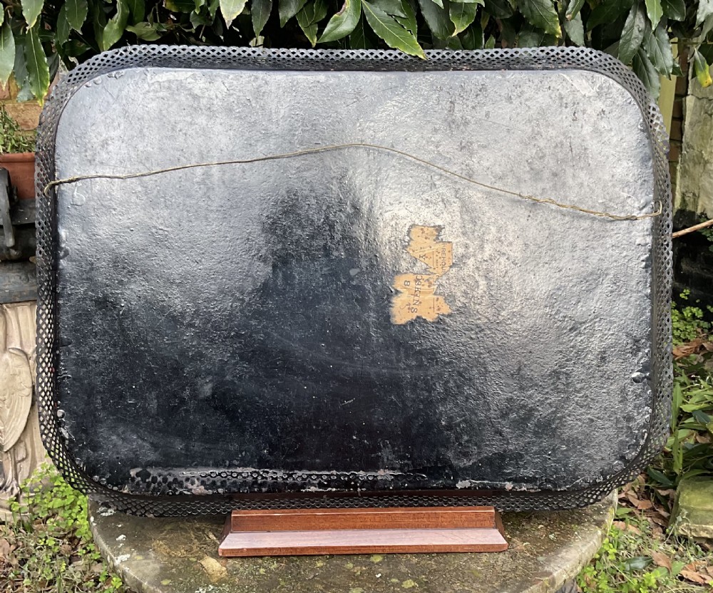 A rectangular black lacquered toleware tray featuring a central handpainted fruit and floral motif surrounded by a pierced metal gallery border. View V