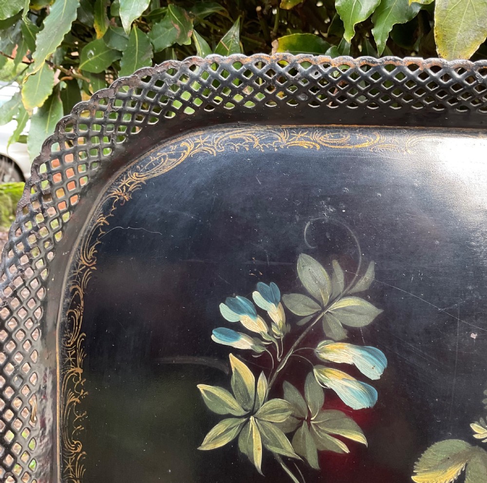 A rectangular black lacquered toleware tray featuring a central handpainted fruit and floral motif surrounded by a pierced metal gallery border. View VI