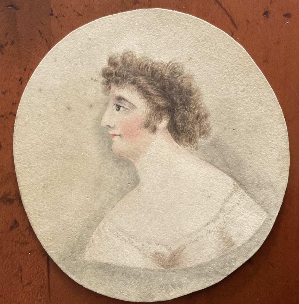 A Regency watercolour profile portrait of a woman surrounded by fourteen hand-painted paper costume overlays with cut-out apertures. View II