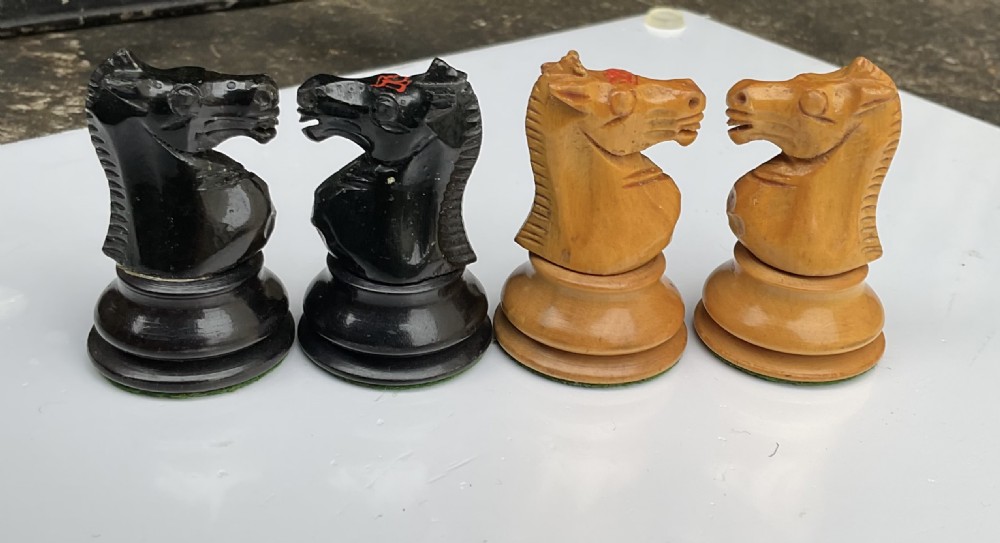 A complete set of turned and carved Staunton chess pieces crafted from light boxwood and black ebony, arranged on a surface. View VI
