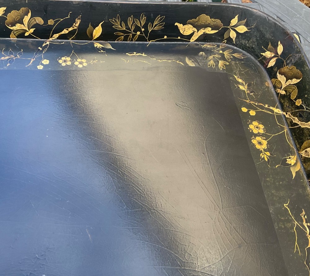 A large rectangular black lacquer papier-mache tray featuring rounded corners and a gilded floral border. View II