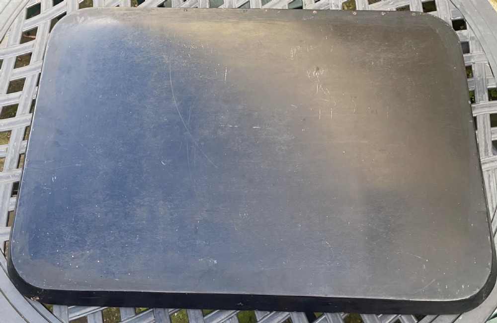 A large rectangular black lacquer papier-mache tray featuring rounded corners and a gilded floral border. View IV