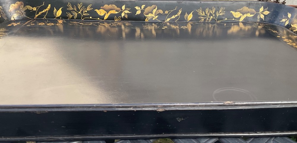 A large rectangular black lacquer papier-mache tray featuring rounded corners and a gilded floral border. View VIII