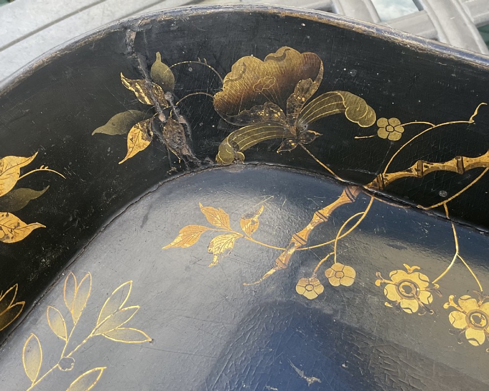 A large rectangular black lacquer papier-mache tray featuring rounded corners and a gilded floral border. View IX
