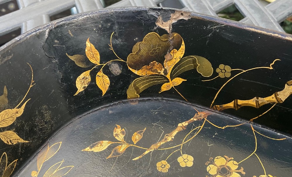 A large rectangular black lacquer papier-mache tray featuring rounded corners and a gilded floral border. View X