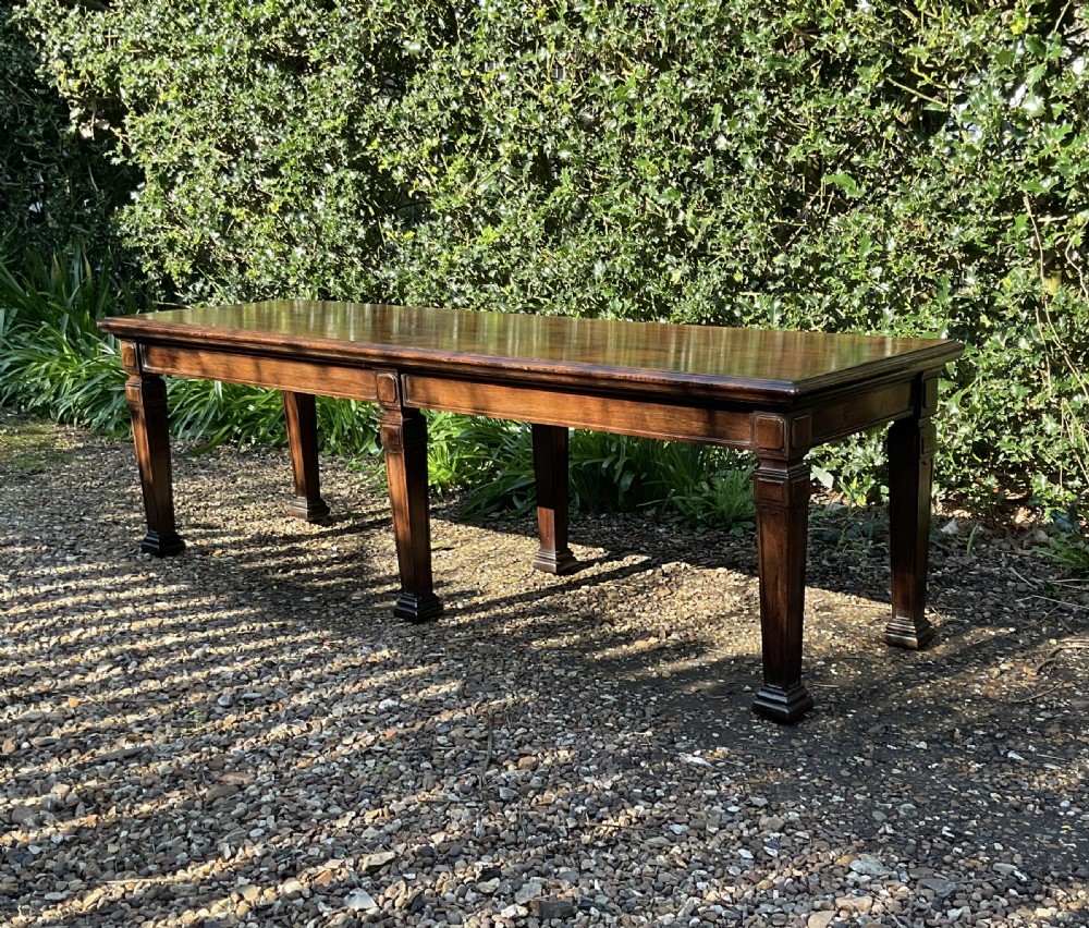 An Edwardian long polished mahogany window seat featuring a rectangular top and six tapered square legs with block details. View III