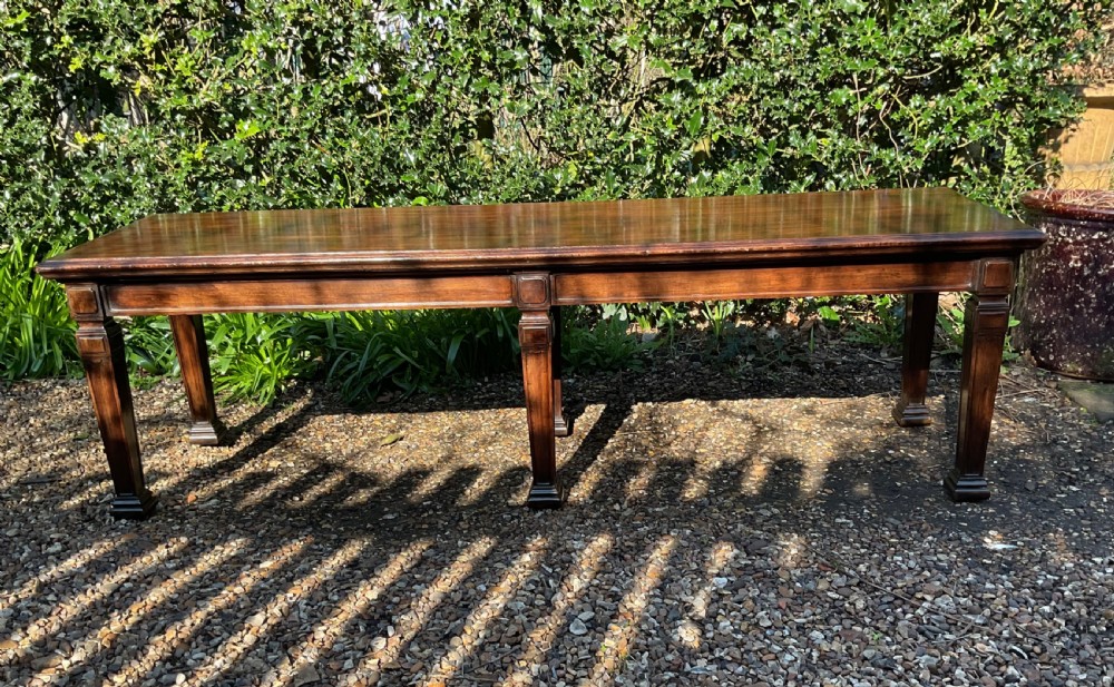 An Edwardian long polished mahogany window seat featuring a rectangular top and six tapered square legs with block details. View IV