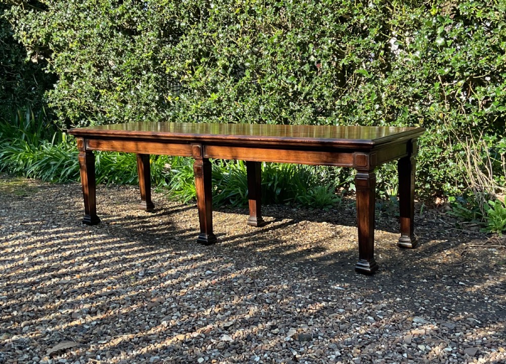 An Edwardian long polished mahogany window seat featuring a rectangular top and six tapered square legs with block details. View VII