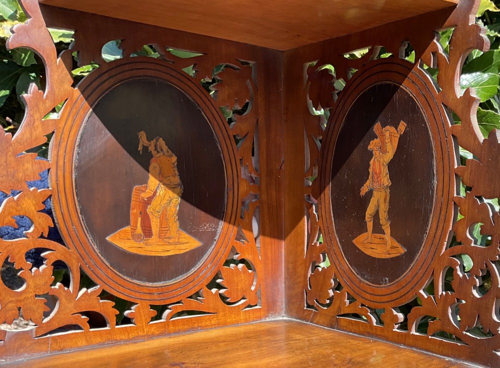 A Victorian three-tiered olive wood corner shelf with pierced fretwork edges and oval inlaid marquetry panels depicting Italian figures. View III