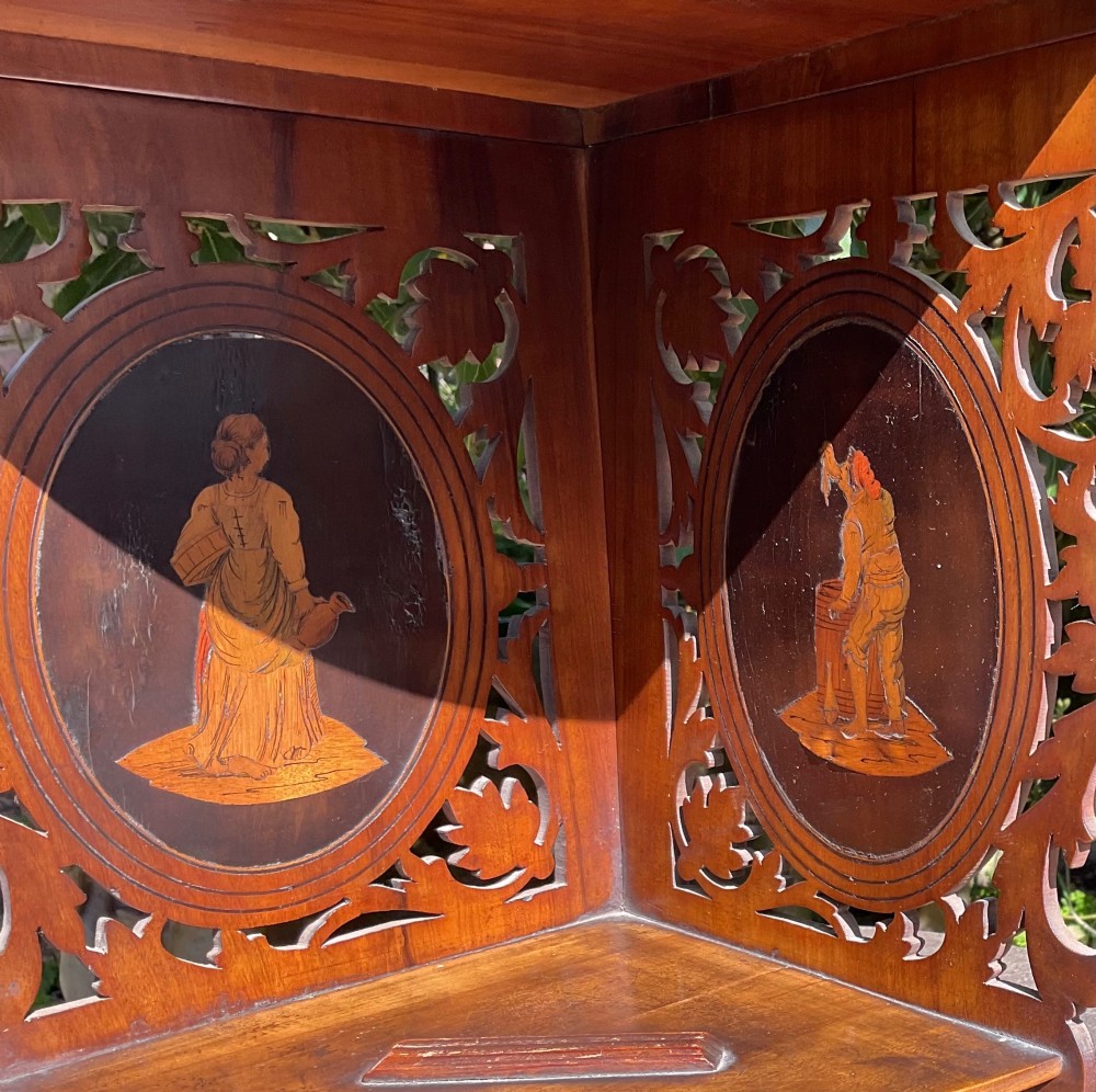 A Victorian three-tiered olive wood corner shelf with pierced fretwork edges and oval inlaid marquetry panels depicting Italian figures. View IV
