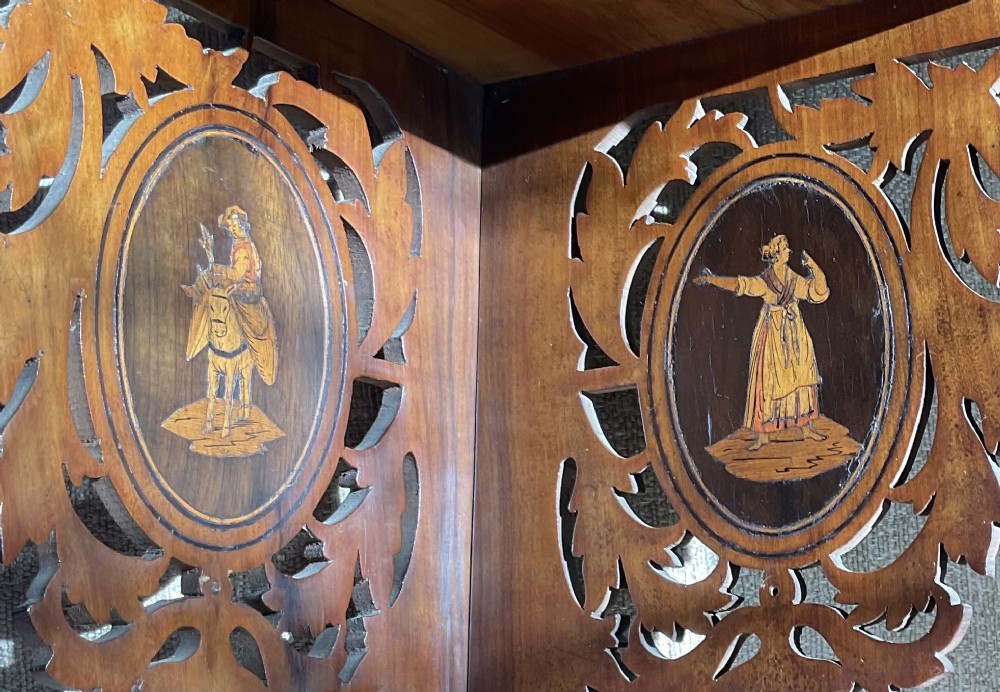 A Victorian three-tiered olive wood corner shelf with pierced fretwork edges and oval inlaid marquetry panels depicting Italian figures. View VI