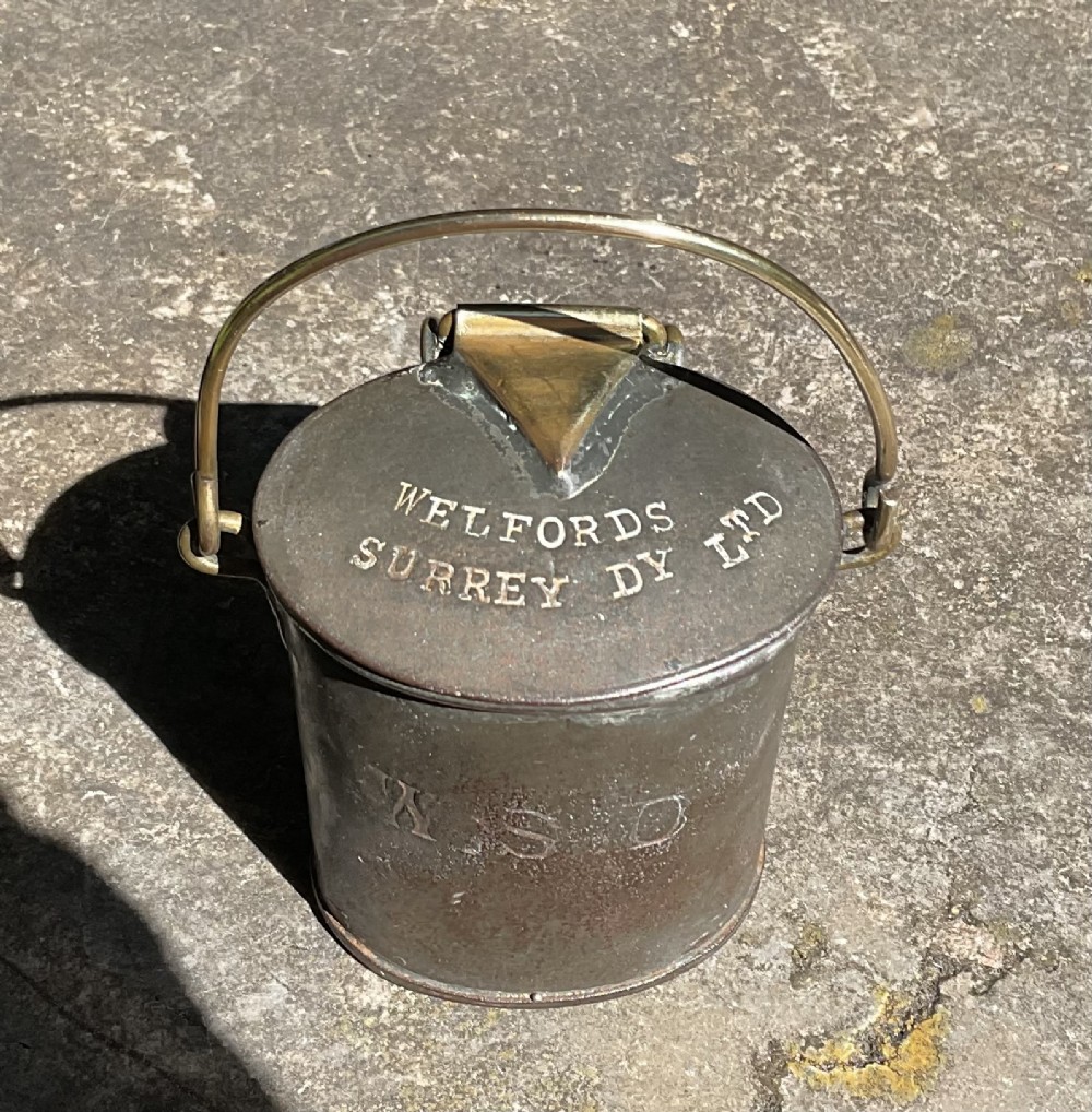 An antique metal dairy cream can featuring a brass swing handle, stamped lid lettering, and a hinged spout cover. View II