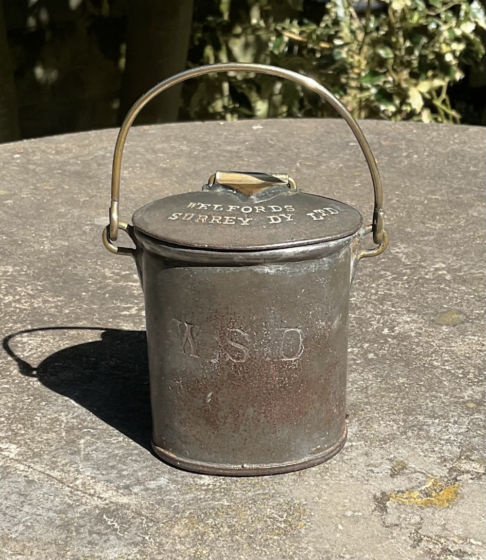 An antique metal dairy cream can featuring a brass swing handle, stamped lid lettering, and a hinged spout cover. View III