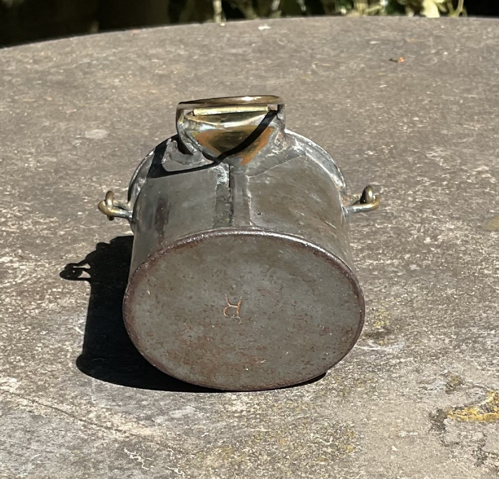 An antique metal dairy cream can featuring a brass swing handle, stamped lid lettering, and a hinged spout cover. View IV
