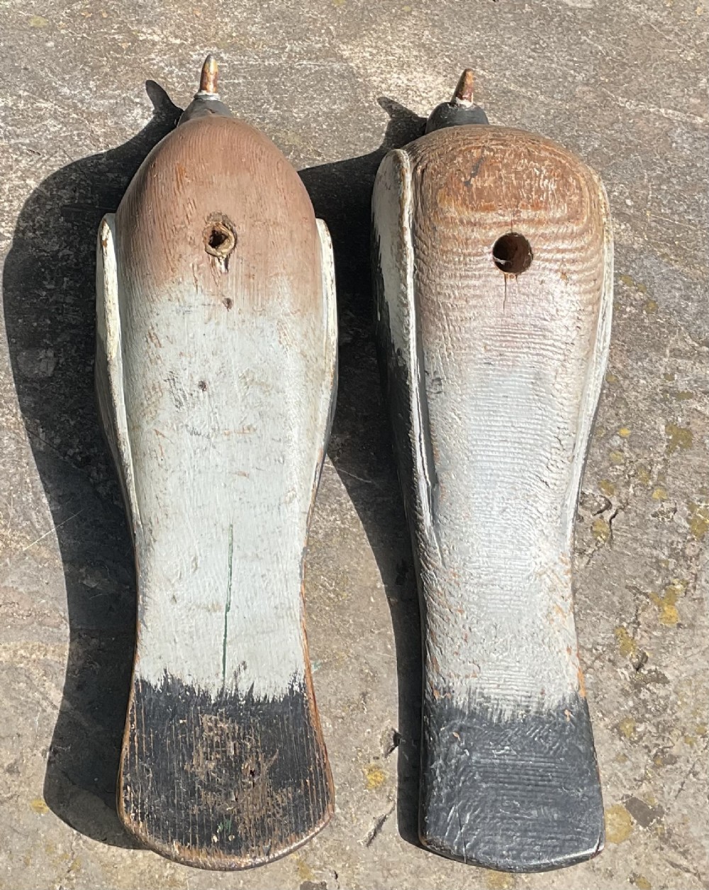 A pair of hand-carved and painted wooden pigeon decoys dating to circa 1900, showing grey and terracotta tones with worn patina. View III