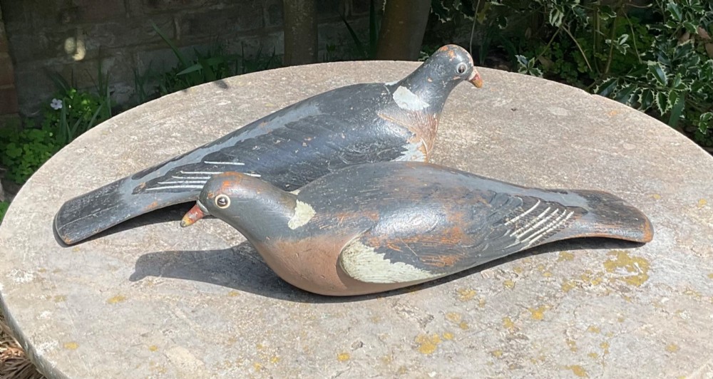 A pair of hand-carved and painted wooden pigeon decoys dating to circa 1900, showing grey and terracotta tones with worn patina. View VI