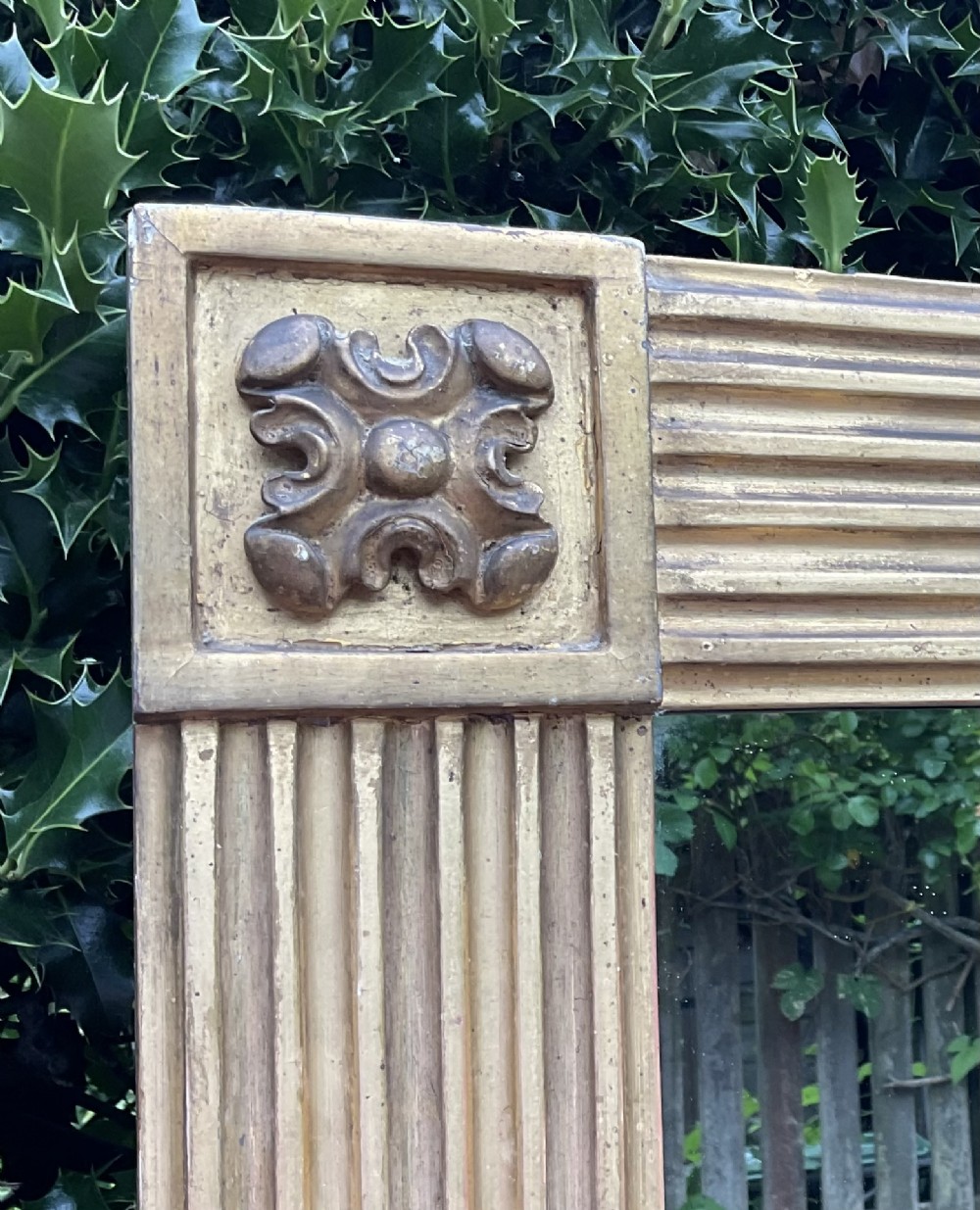 A tall Regency giltwood pier mirror featuring a fluted frame with carved corner rosettes. View II