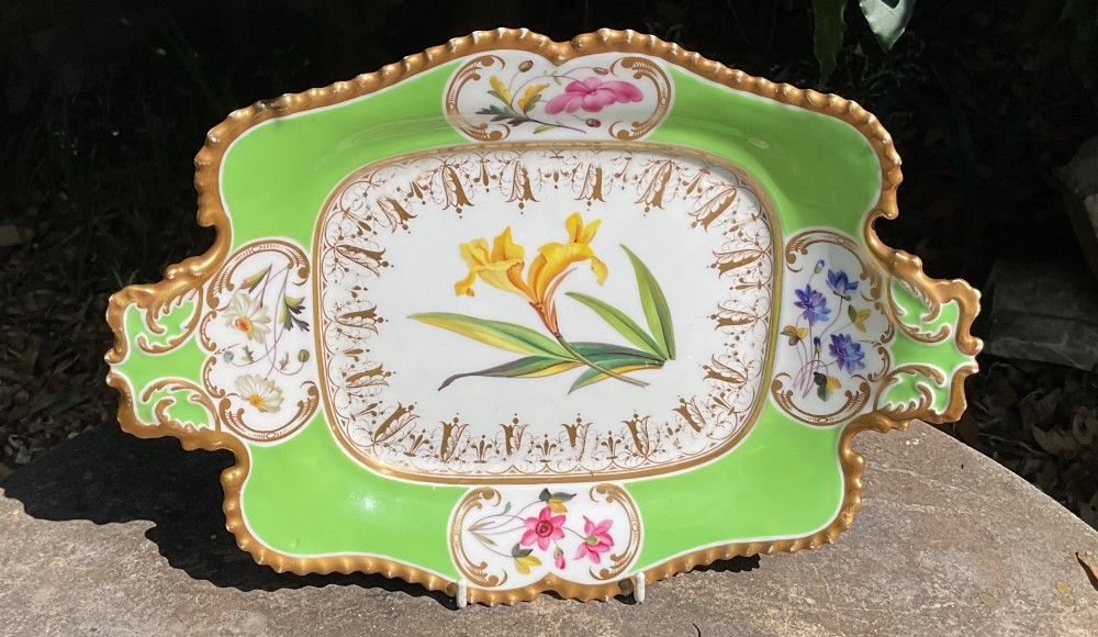 A set of four Regency period Chamberlains Worcester porcelain serving dishes featuring bright apple green borders, gilt scrollwork, and individual hand-painted central botanical flowers. View IV